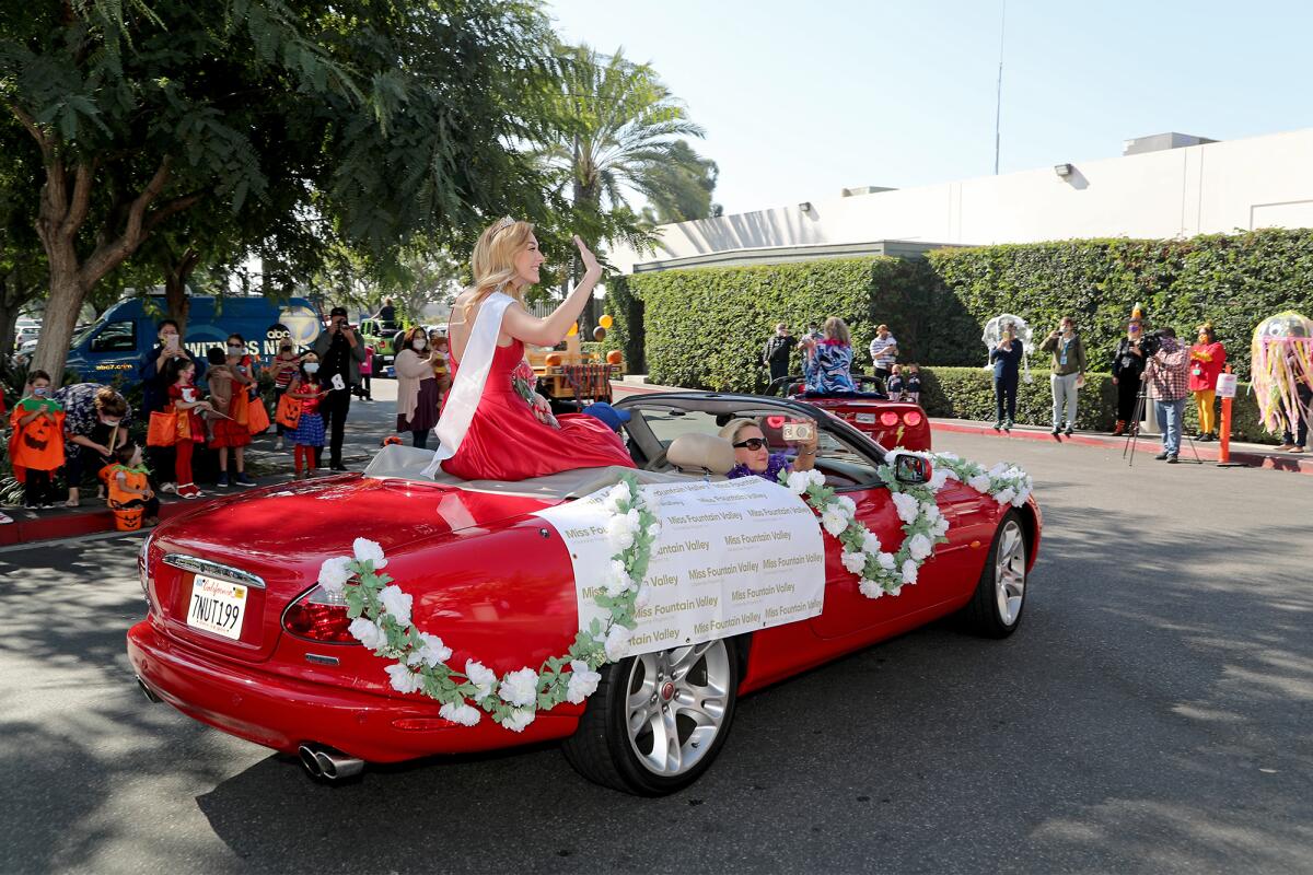 Miss Fountain Valley's Helen Reynolds waves as she participates in the 14th annual Pediatric Trick-Or-Treat Parade.