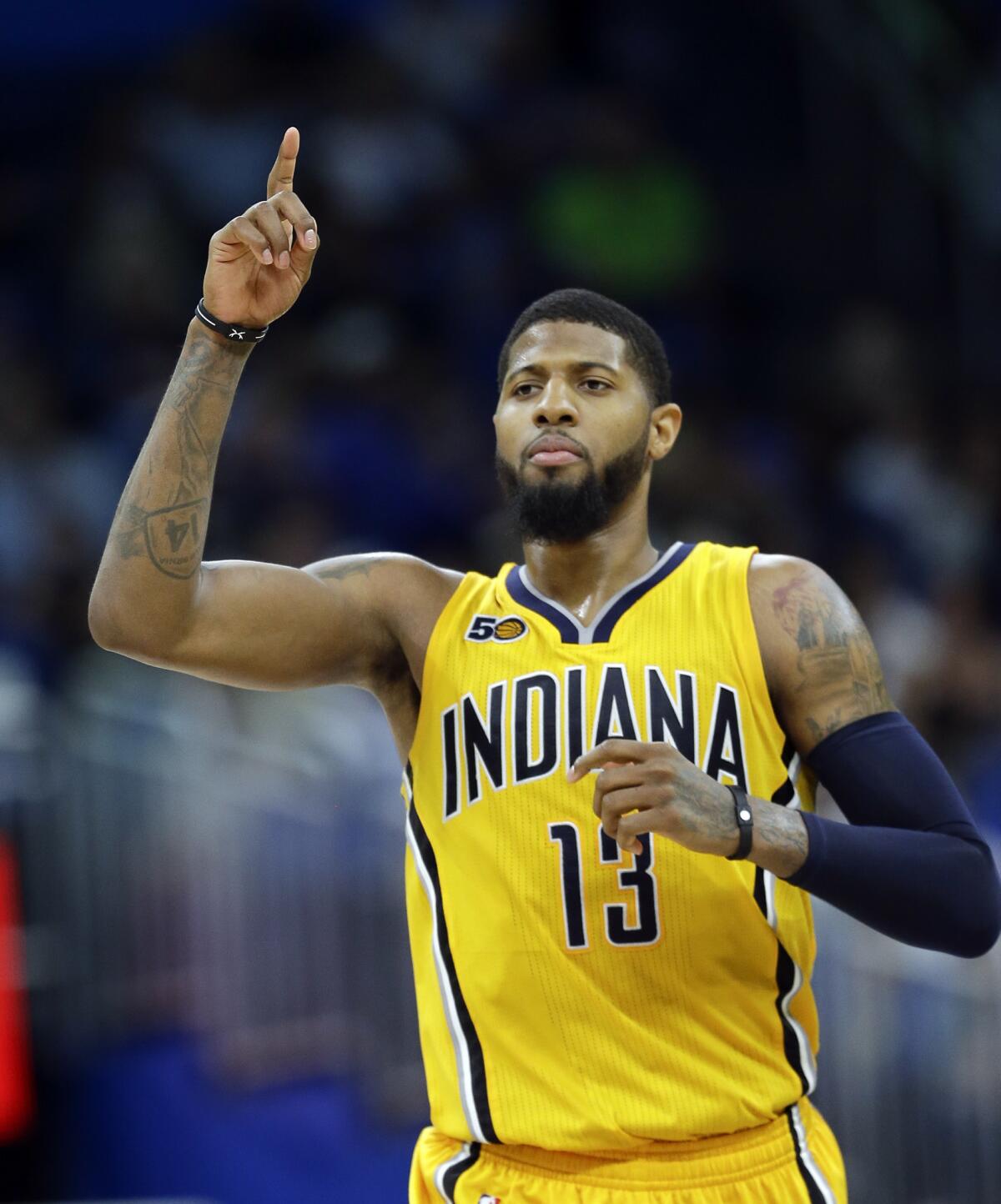 FILE - In this April 8, 2017, file photo, Indiana Pacers' Paul George gestures after making a 3-point basket against the Orlando Magic during an NBA basketball game in Orlando, Fla. George is committed to playing for the Pacers next season. After that, it's anybody's guess. The four-time All-Star forward provided clarity on his short-term plan Thursday before playing in a charity softball game just a short walk away from the only NBA arena he's called home. (AP Photo/John Raoux, File)