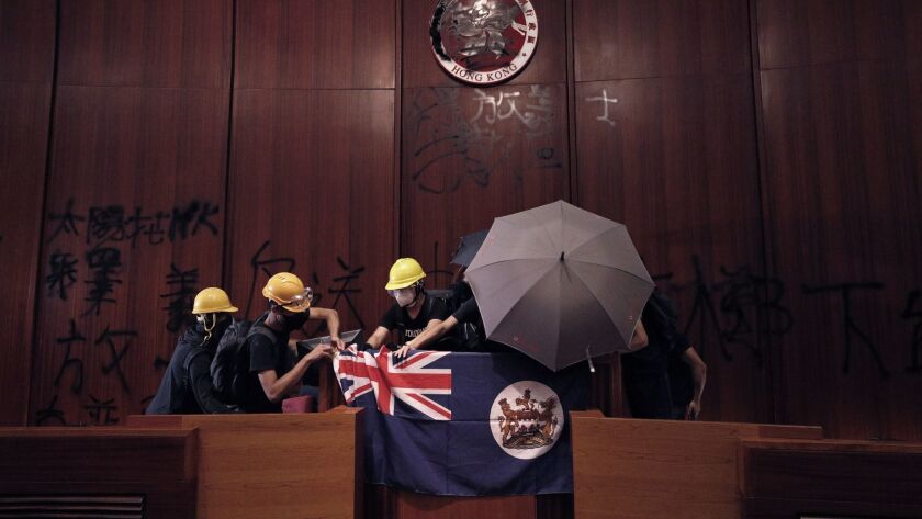 Protesters pin a Hong Kong colonial flag in the Legislative Chamber after they broke into the building July 1.