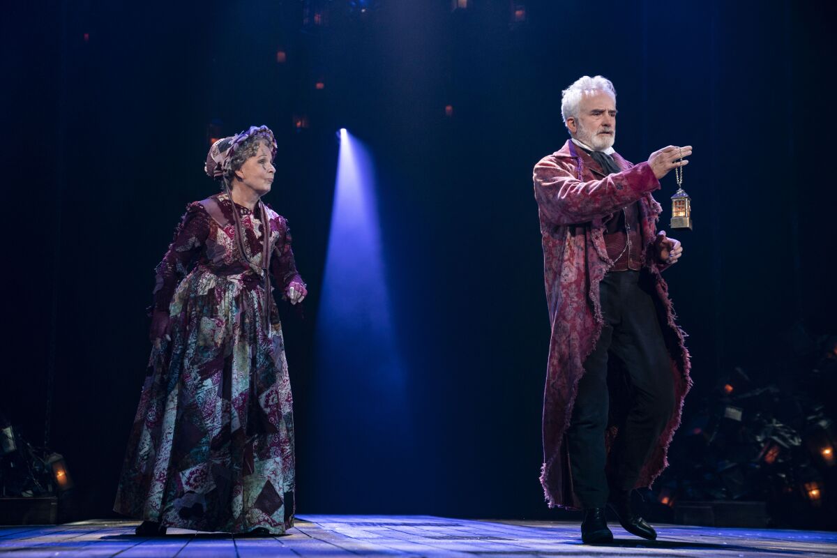 Actors in stylized Victorian clothing perform "A Christmas Carol" at the Ahmanson Theatre.