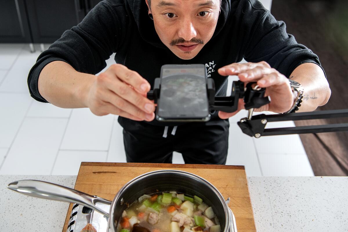 Chris Oh films the making of his cheesy Japanese curry chicken pot pie at his home in Los Angeles.