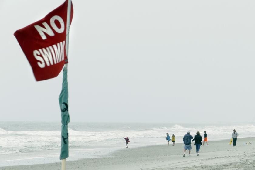 Due to a National Weather Service advisory of strong rip currents, some beaches are closed to swimming. A lifeguard, right, in Myrtle Beach talks with people about staying out of the water.