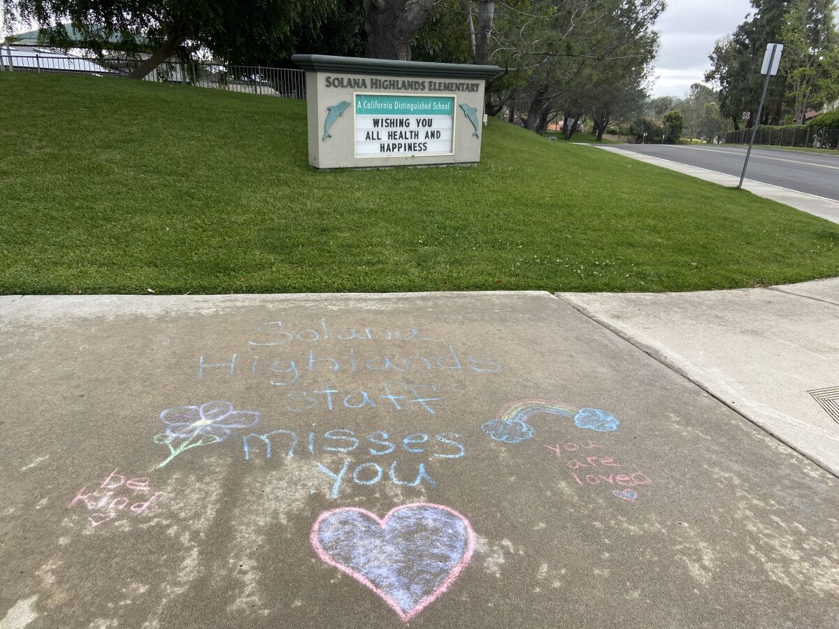 "Solana Highlands staff misses you" and "You are loved" reads the messages in chalk in front of the school.