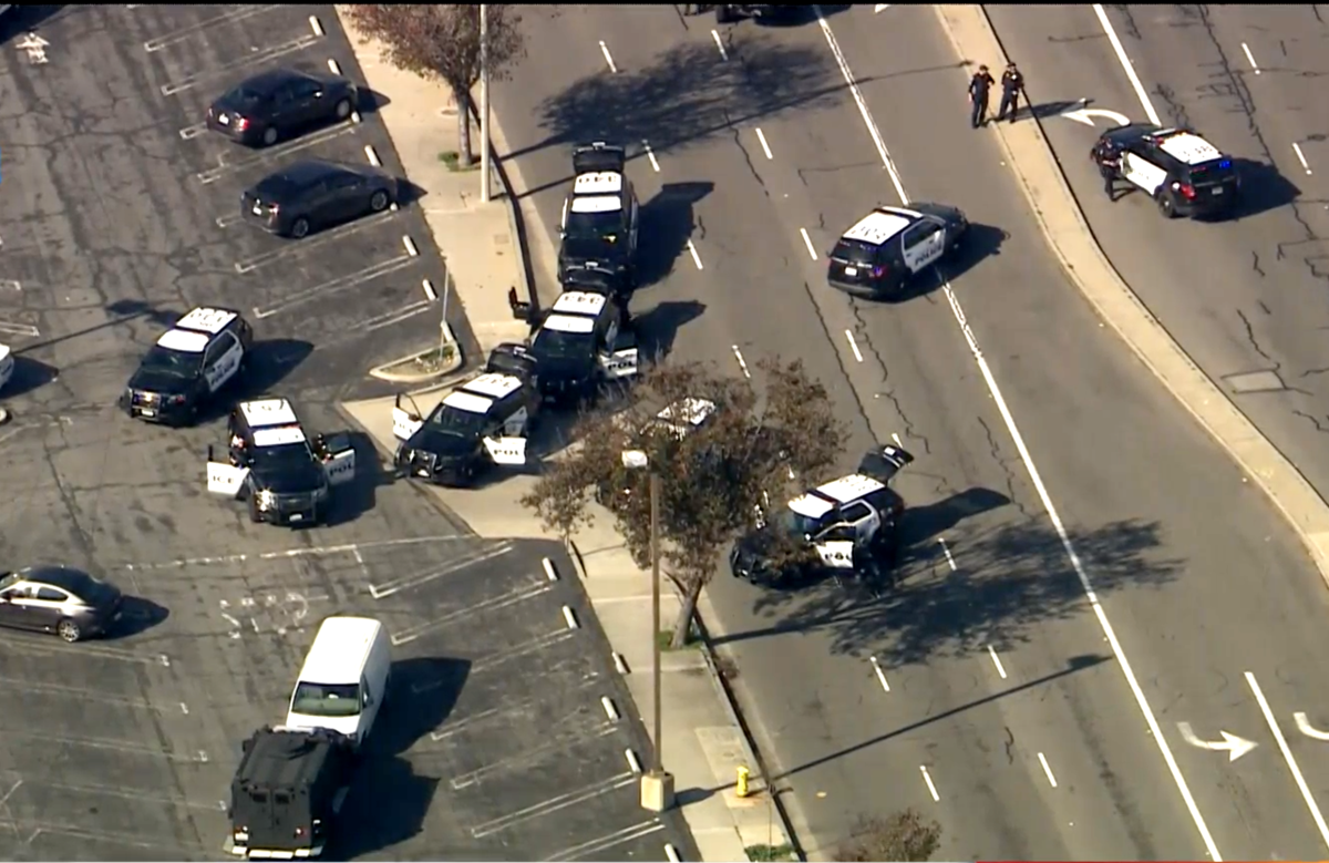 Police cars surround a white van in a parking lot near the Del Amo mall.