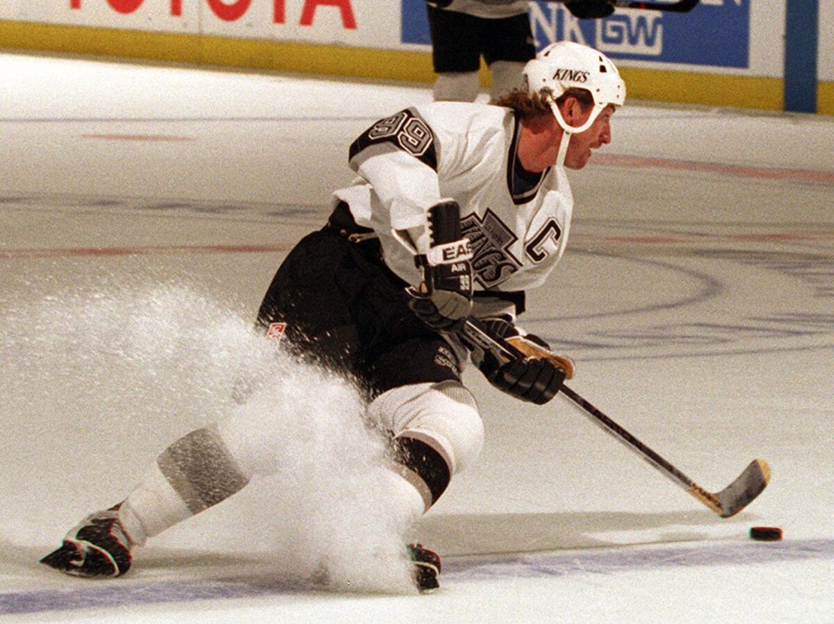Kings great Wayne Gretzky cuts back while controlling the puck during a game against the Vancouver Canucks at the Forum in 1995.