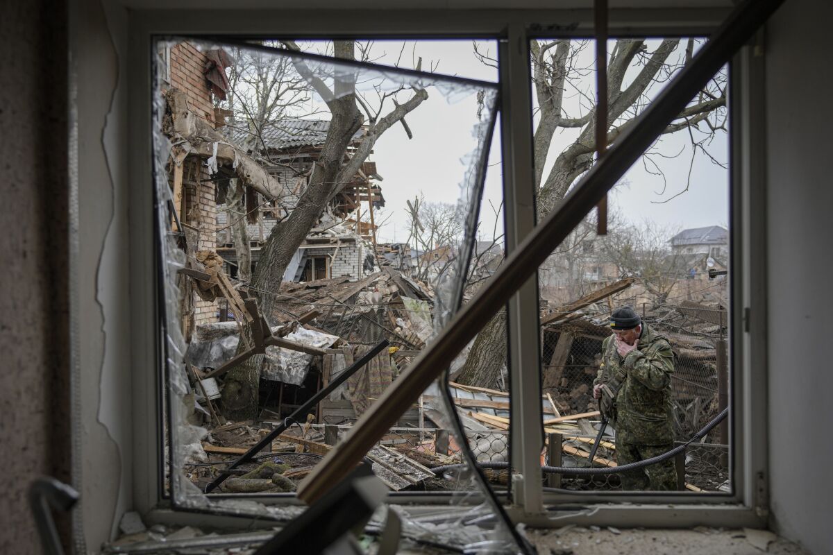 Andrey Goncharuk, 68, a member of territorial defense wipes his face in the backyard of a house that was damaged by a Russian airstrike, according to locals, in Gorenka, outside the capital Kyiv, Ukraine, Wednesday, March 2, 2022. (AP Photo/Vadim Ghirda)