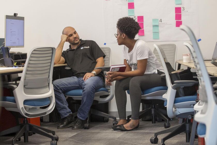 Xavier Rodriguez, with his business Faveo, an on demand labor provider, talks with Rosa Adam, owner of Shukor Bella, a business that makes Ethiopian hair and skin products, talk at the new Connect All small business incubator at the Jacobs Center in San Diego, CA., on Friday, May 17, 2019.