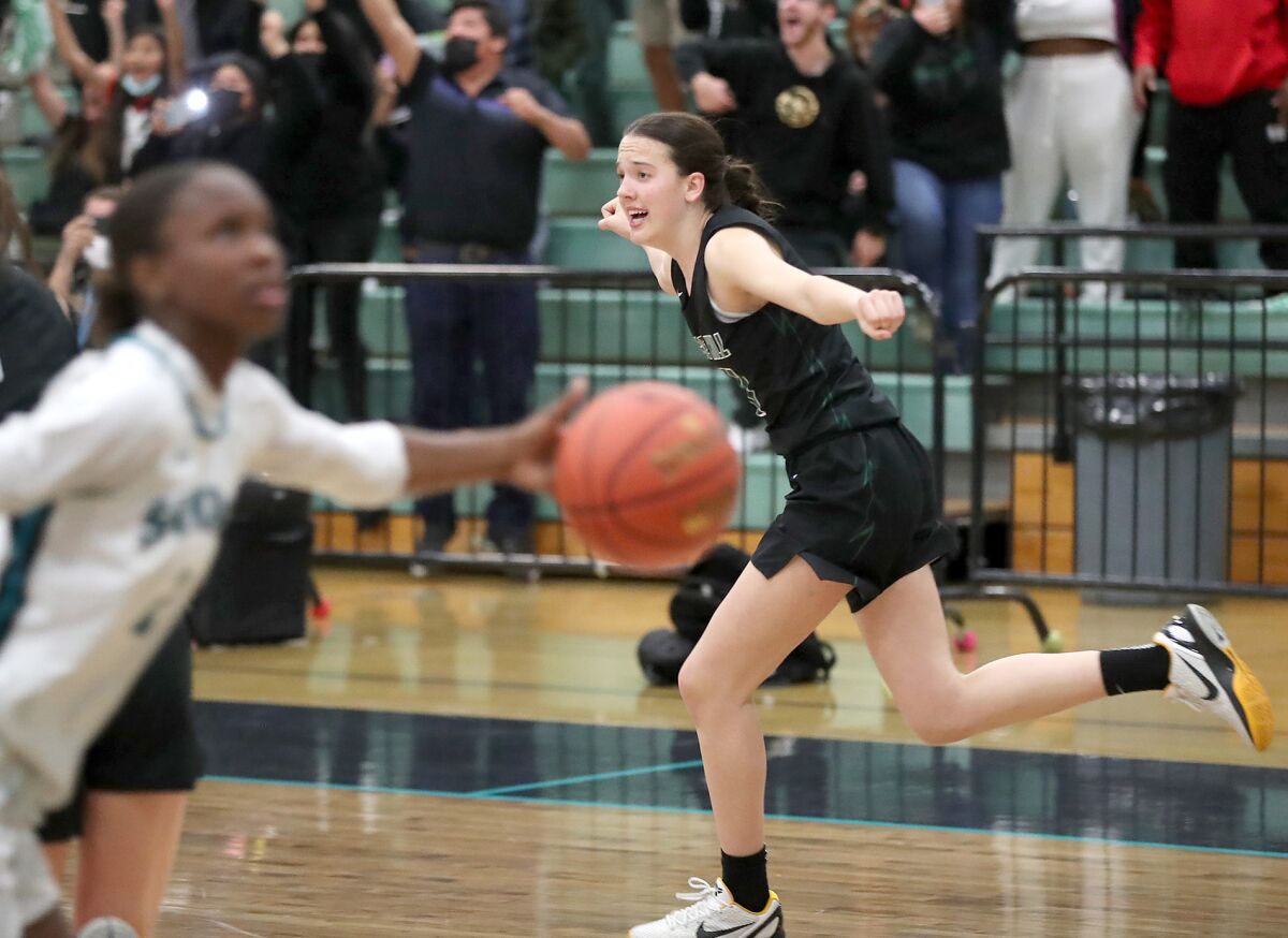 Sage Hill's Kat Righeimer (11) runs up the court after sinking the game-winning basket against Corona Santiago on Tuesday.