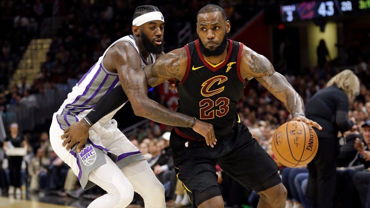 Cleveland Cavaliers' LeBron James, right, drives against Sacramento Kings' JaKarr Sampson in the first half on Wednesday.