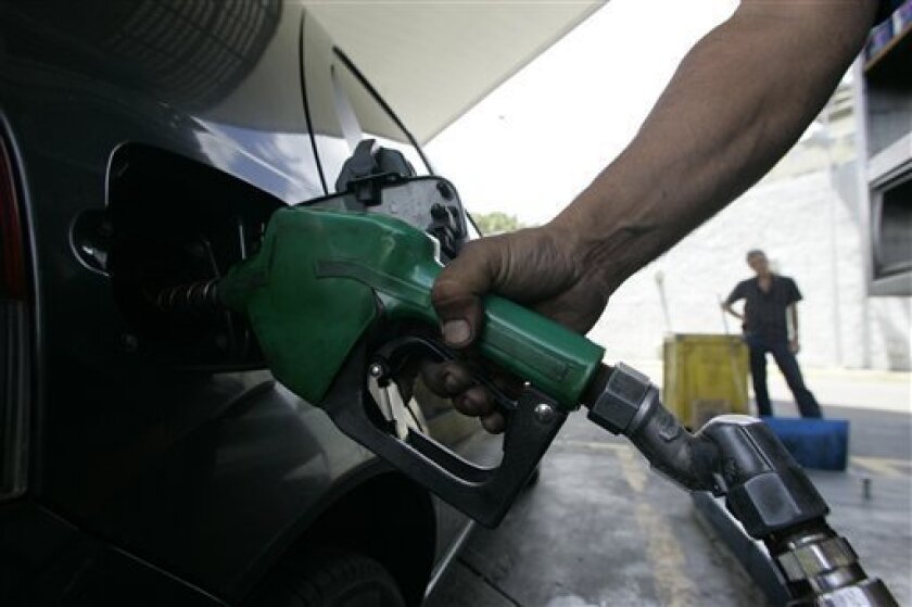 A gas station worker charges gasoline into a car's tank in Caracas, Friday, March 20, 2009. Venezuelans pay as little as 12 cents a gallon (3 cents a liter), a privilege many view as their birthright. (AP Photo/Howard Yanes)