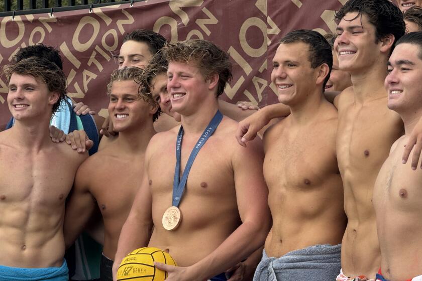 Former JSerra water polo star Ryder Dodd poses for a photo with JSerra players.