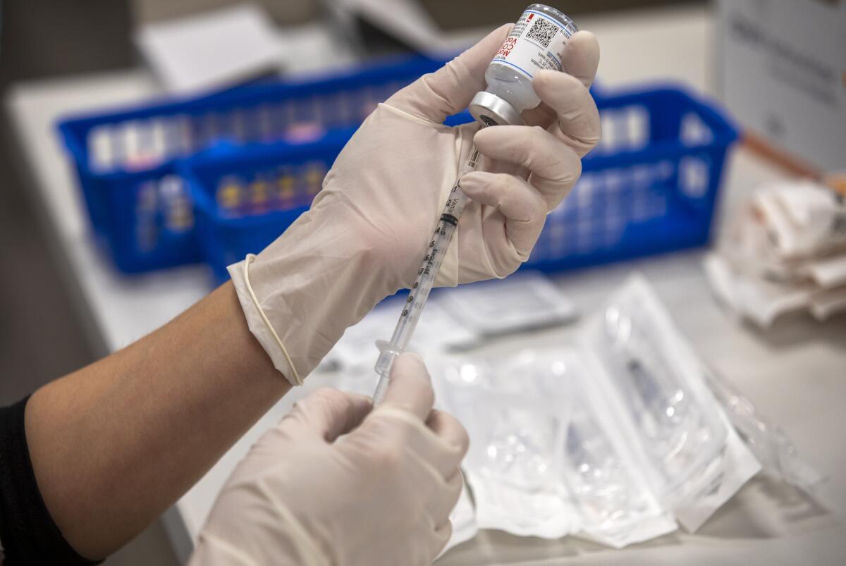 A Moderna COVID-19 vaccine is prepared.