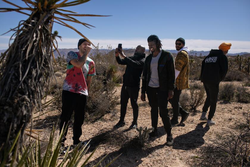 YUCCA VALLEY, CA - FEBRUARY 19: Bobby Brown (left) along with members of Bobby's Donuts With Dads group take a walk amongst Joshua trees during their self care weekend in Yucca Valley on Sunday, Feb. 19, 2023 in Yucca Valley, CA. (Jason Armond / Los Angeles Times)