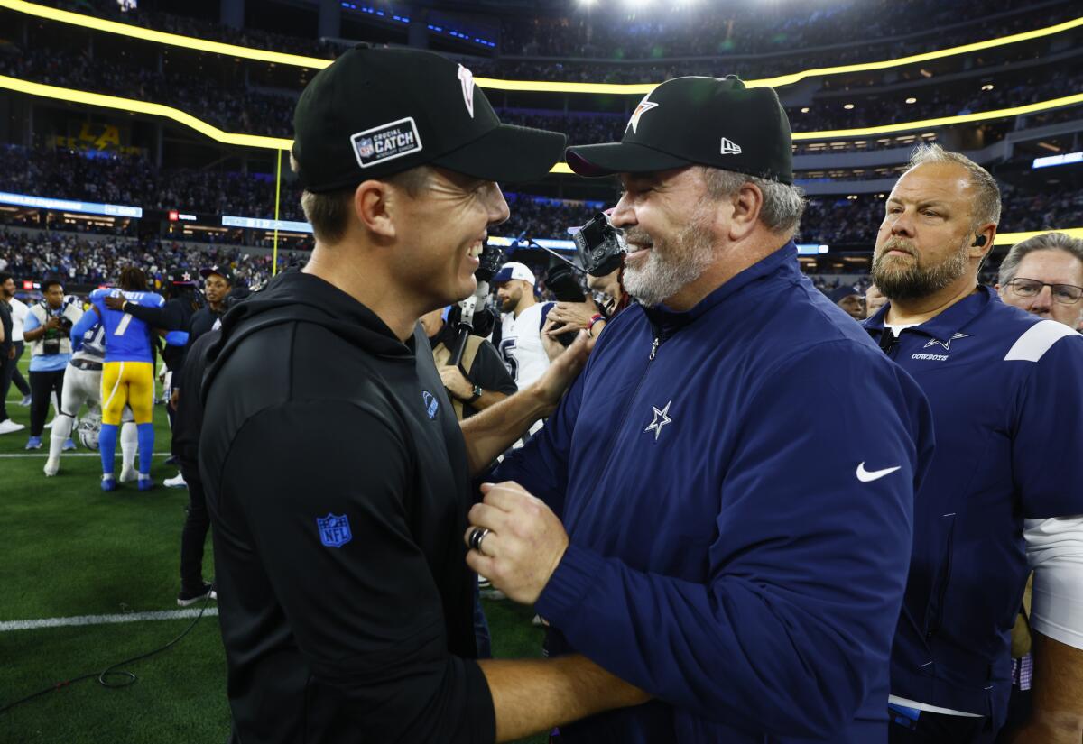 Chargers offensive coordinator Kellen Moore greets Dallas Cowboys head coach Mike McCarthy.