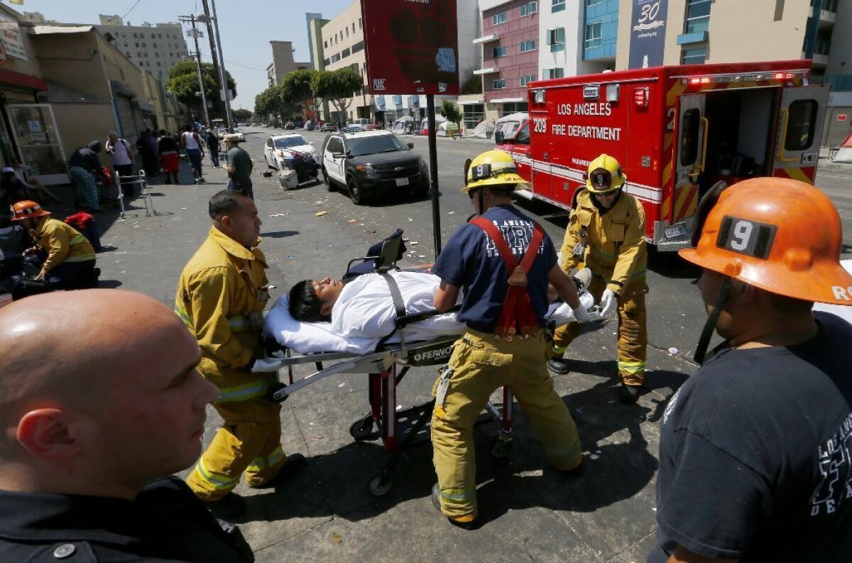 Fire Department personnel provide assistance to a man believed to be feeling the effects of a synthetic cannabinoid called spice on Monday, Aug. 22, 2016, in downtown's Skid Row