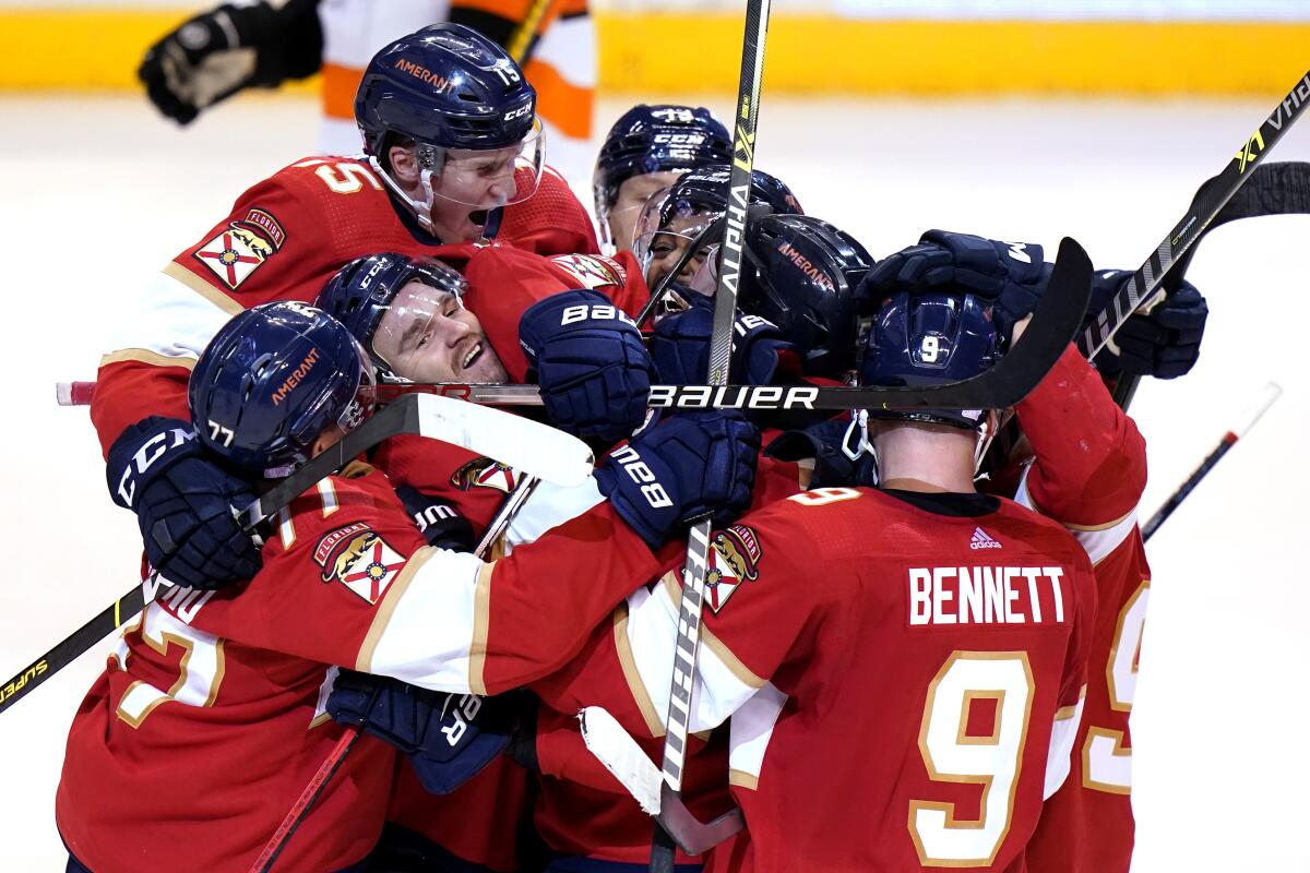 Florida Panthers defenseman Aaron Ekblad, left, celebrates with his teammates after scoring the game-winning goal during overtime in an NHL hockey game, Wednesday, Nov. 24, 2021, in Sunrise, Fla. The Panthers won 2-1 in overtime. (AP Photo/Lynne Sladky)