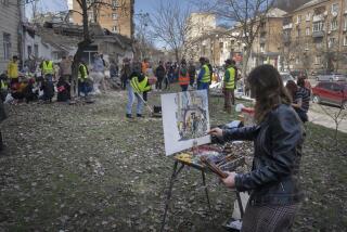 A student of Kyiv State Arts Academy paints as other students and volunteers clear the rubble after the Academy was partly ruined during the Russian missile attack a few days ago in Kyiv, Ukraine, Saturday, March 30, 2024. (AP Photo/Efrem Lukatsky)