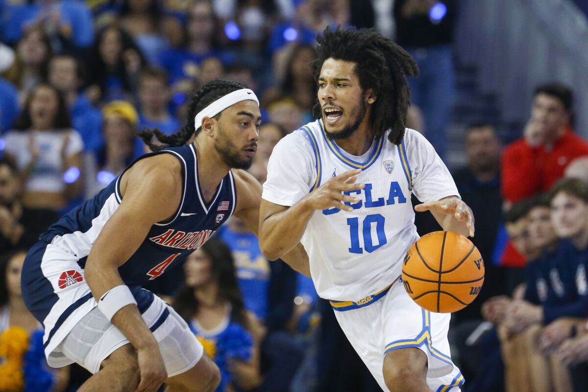 UCLA guard Tyger Campbell, right, drives past Arizona guard Kylan Boswell.