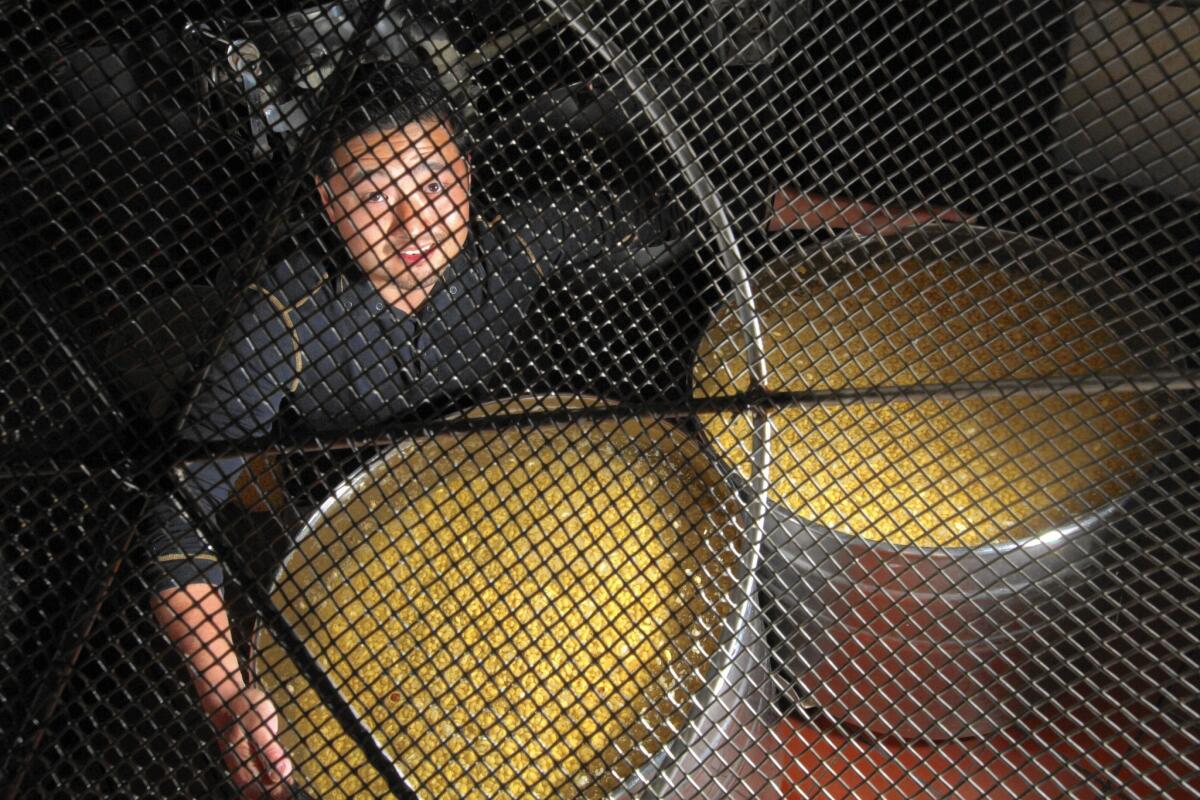 Koki Sato with tubs of soybeans soaking in water that will be used to make tofu at Gardena-based Meiji Tofu.