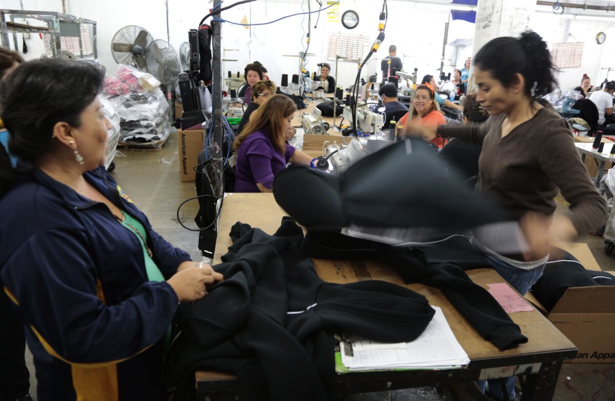 American Apparel workers sew and package black hoodies at the company's Los Angeles factory on Feb. 27, 2015.