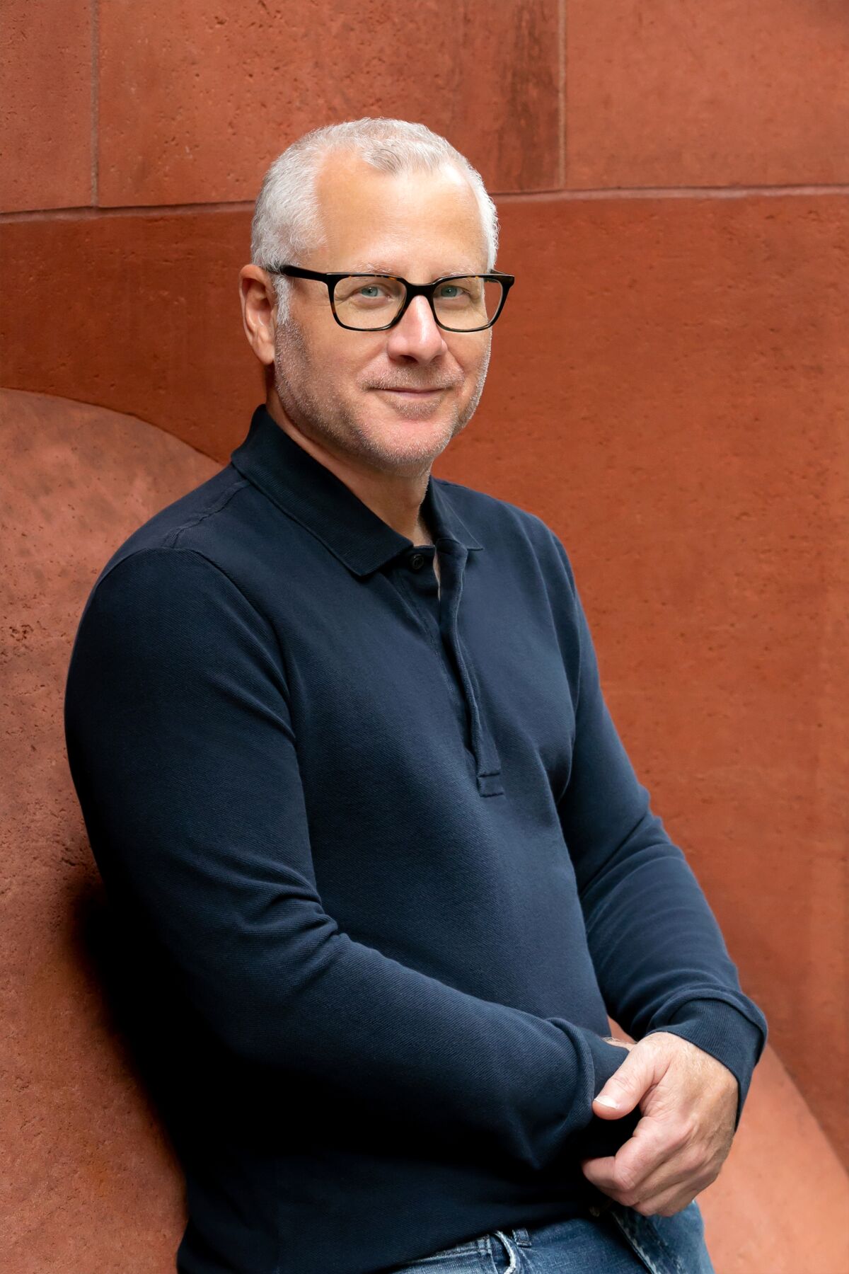 a man leans against a brick wall