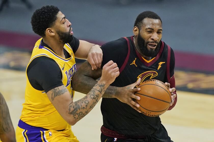 Cleveland Cavaliers' Andre Drummond, right, drives past Los Angeles Lakers' Anthony Davis in the first half of an NBA basketball game, Monday, Jan. 25, 2021, in Cleveland. (AP Photo/Tony Dejak)