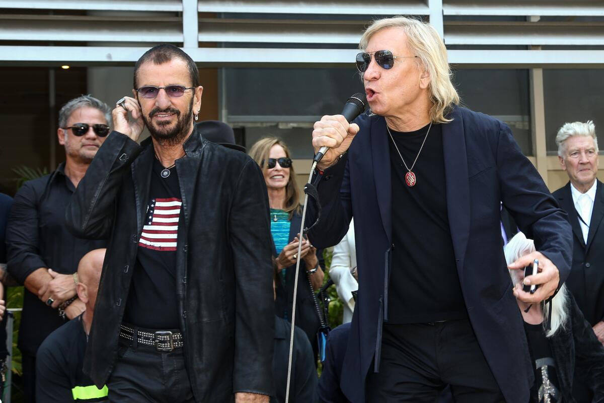 Ringo Starr, left, was joined on the microphone by Eagles guitarist, singer and songwriter Joe Walsh, who also is his brother-in-law, at Thursday's "Peace and Love" ceremony marking the ex-Beatle's 76th birthday in Hollywood.