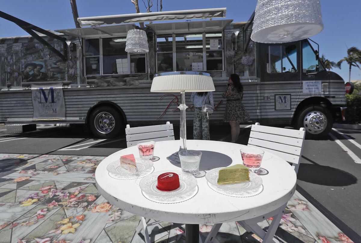 A table of selects outside the luxury cake truck Lady M parked outside Macy's at South Coast Plaza.