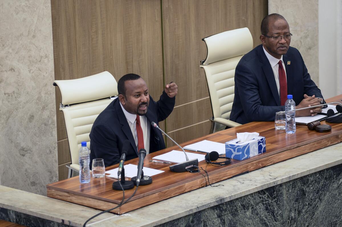 Ethiopia's Prime Minister Abiy Ahmed, left, accompanied by House speaker Tagesse Chafo, right, addresses the parliament in the capital Addis Ababa, Ethiopia Tuesday, Nov. 15, 2022. Abiy said Tuesday that the future status of disputed territory in the western part of the country's Tigray region will be settled according to the Ethiopian constitution, following the signing of a truce earlier this month. (AP Photo)