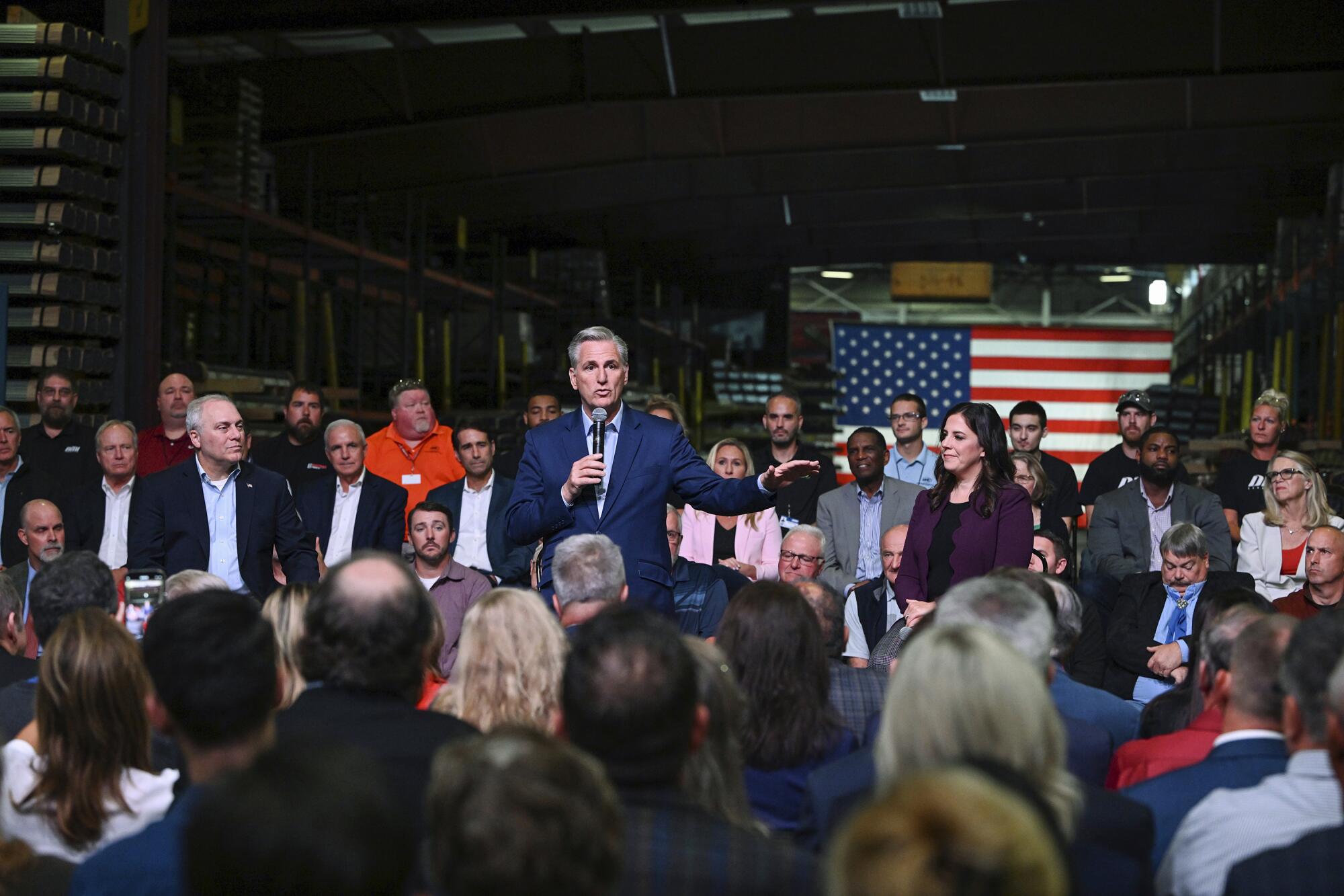 A man with a microphone is surrounded by people.