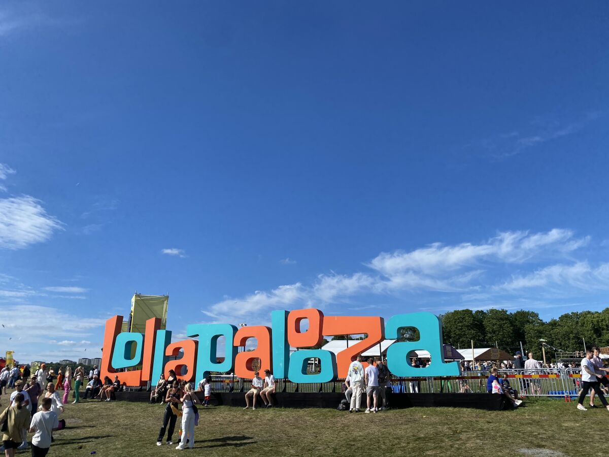 A large Lollapalooza sign, surrounded by festival-goers