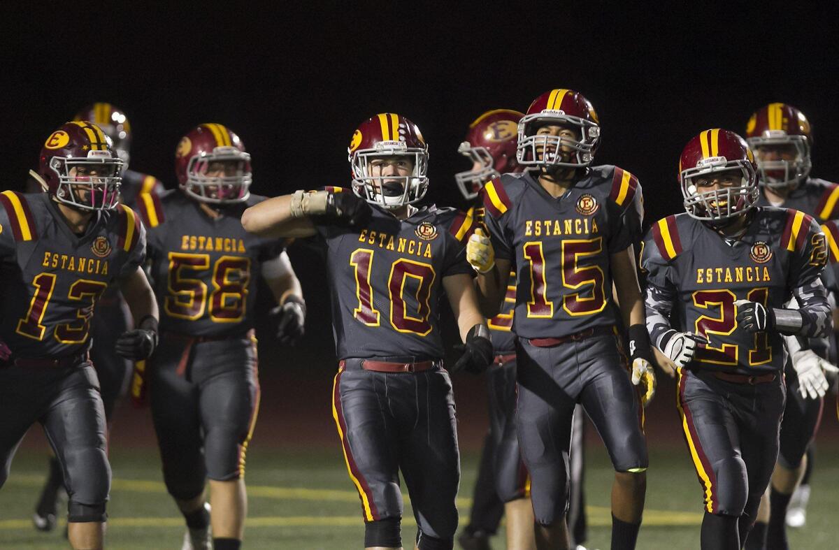 After scoring a touchdown on the first play of the game, Estancia’s Tyler Ross (10) celebrates with Vincent Durarte (15) and Jordan Alcazar (21) during the Battle for the Bell.