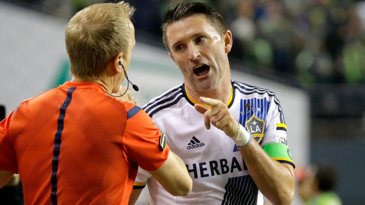 Galaxy forward Robbie Keane talks with referee's assistant Corey Rockwell during a season-ending 3-2 loss to the Sounders on Wednesday night in Seattle.