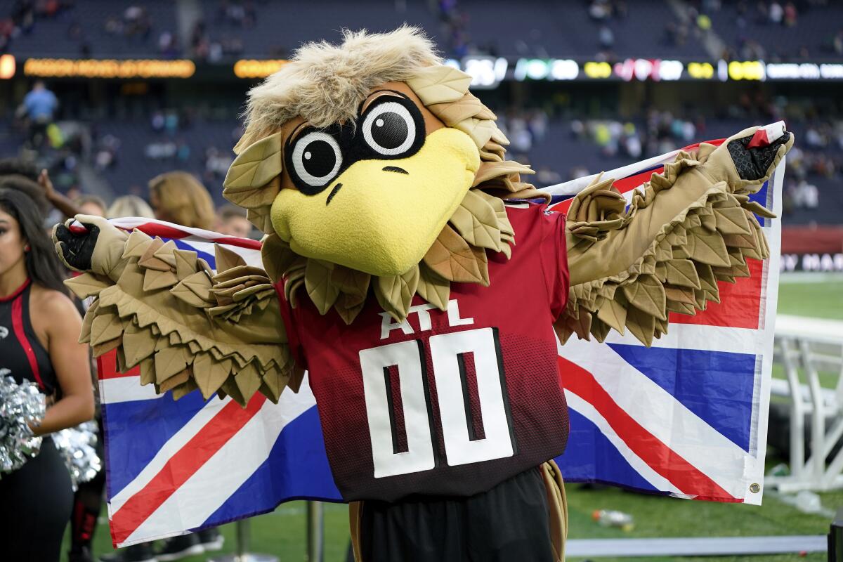 The Atlanta Falcons mascot Freddie Falcon holds a Union flag after an NFL football game 