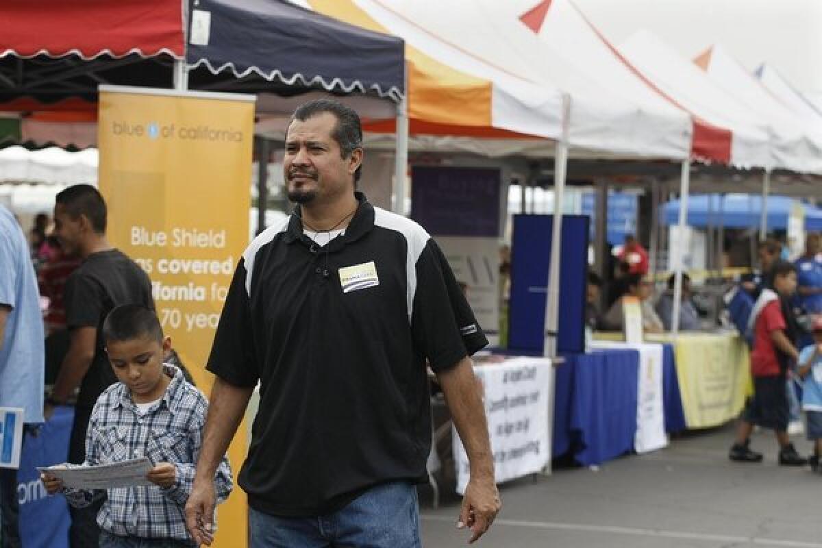 Luis Ramos, with his son Jacob, sought information on the Affordable Care Act last month at the East Los Angeles Health Fair.
