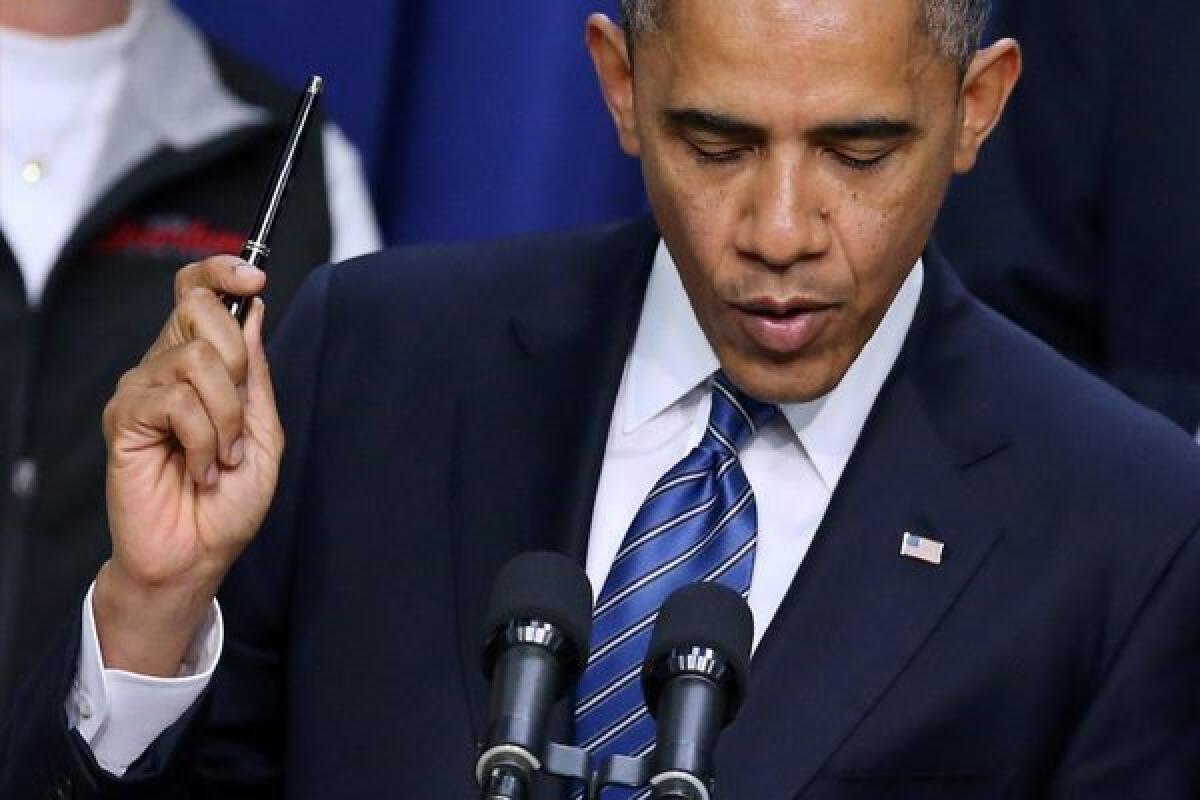 President Obama holds a pen while saying he is ready to sign legislation to extend tax cuts for lower- and middle-income taxpayers during an event in the Eisenhower Executive Office Building on Wednesday.