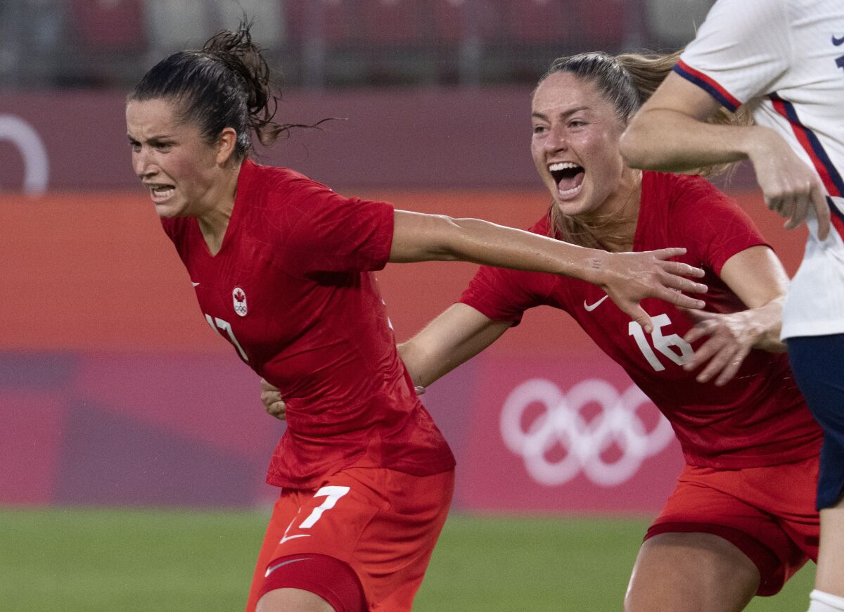 Canada midfielder Jessie Fleming (17) celebrates her game winning penalty kick goal with teammate Janine Beckie (16) during a women's semifinal soccer match against United States at the 2020 Summer Olympics, Monday, Aug. 2, 2021, in Kashima, Japan. (Frank Gunn/The Canadian Press via AP)