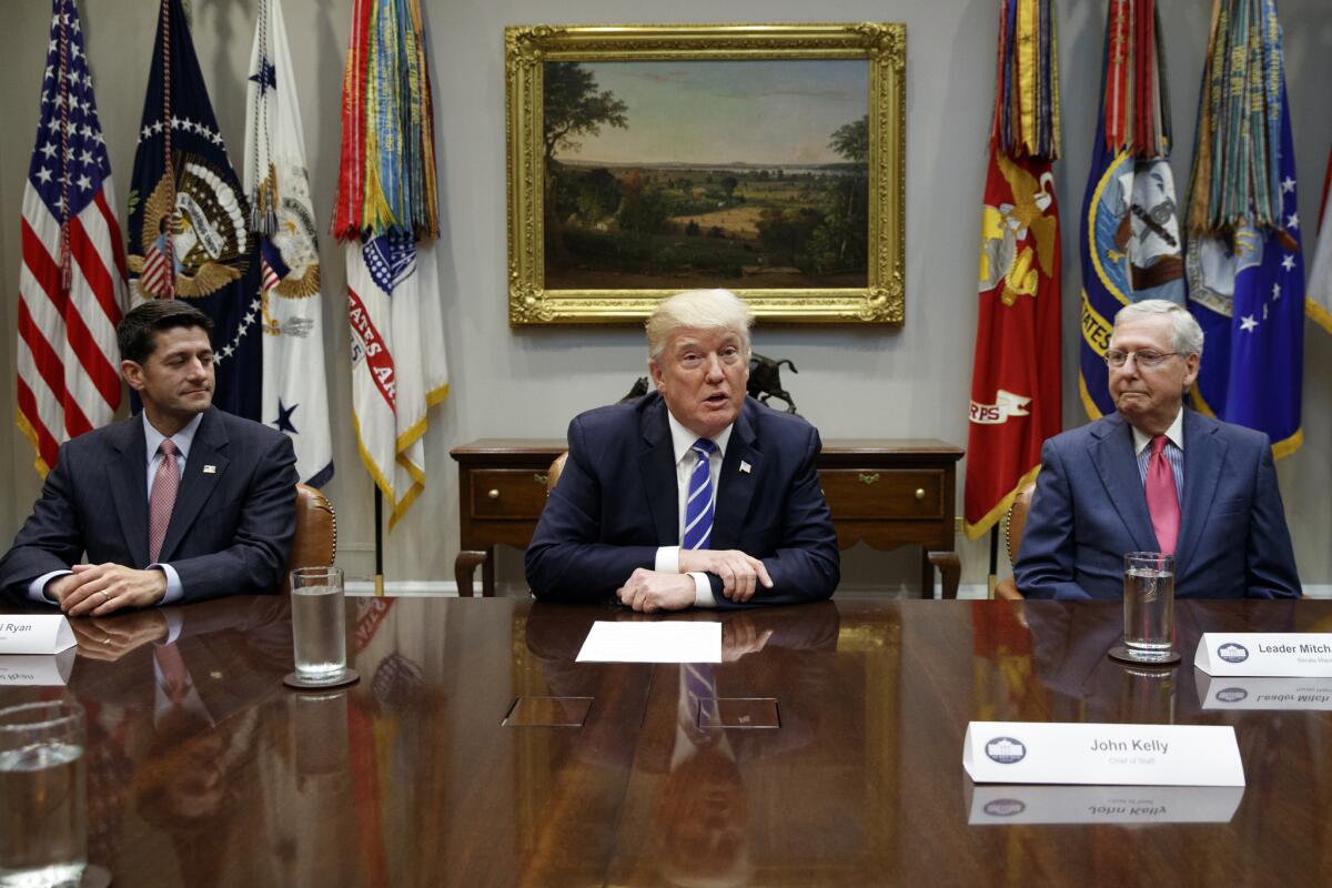 House Speaker Paul D. Ryan (R-Wis.), left, and Senate Majority Leader Mitch McConnell (R-Ky.), right, listen as President Trump speaks on tax reform earlier this year at the White House.