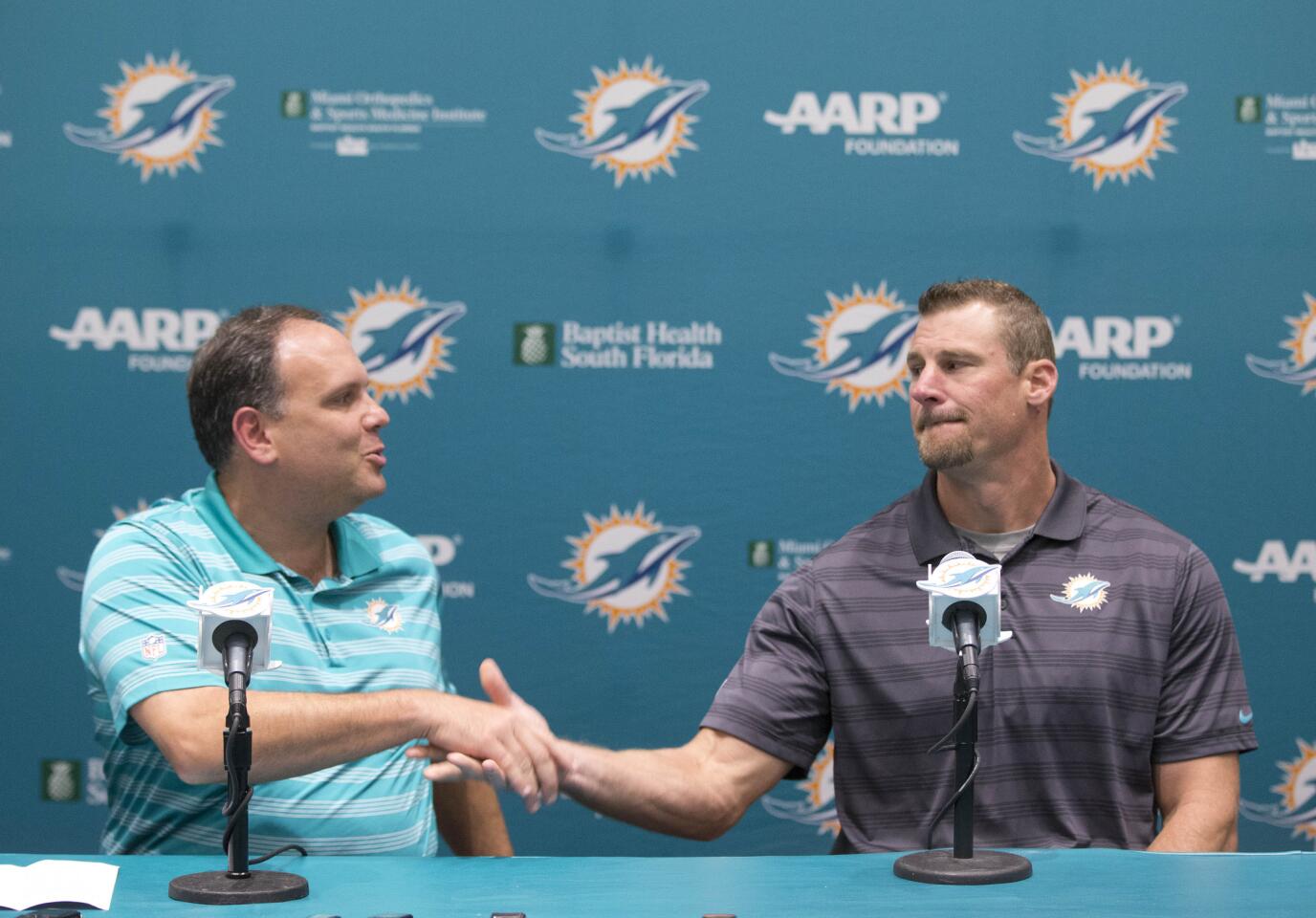 Mike Tannenbaum, left, Miami Dolphins executive vice president of football operations, shakes hands with former tight ends coach Dan Campbell, after announcing that Campbell was being promoted to interim head coach, Monday, Oct. 5, 2015 in Davie, Fla. (AP Photo/Wilfredo Lee)