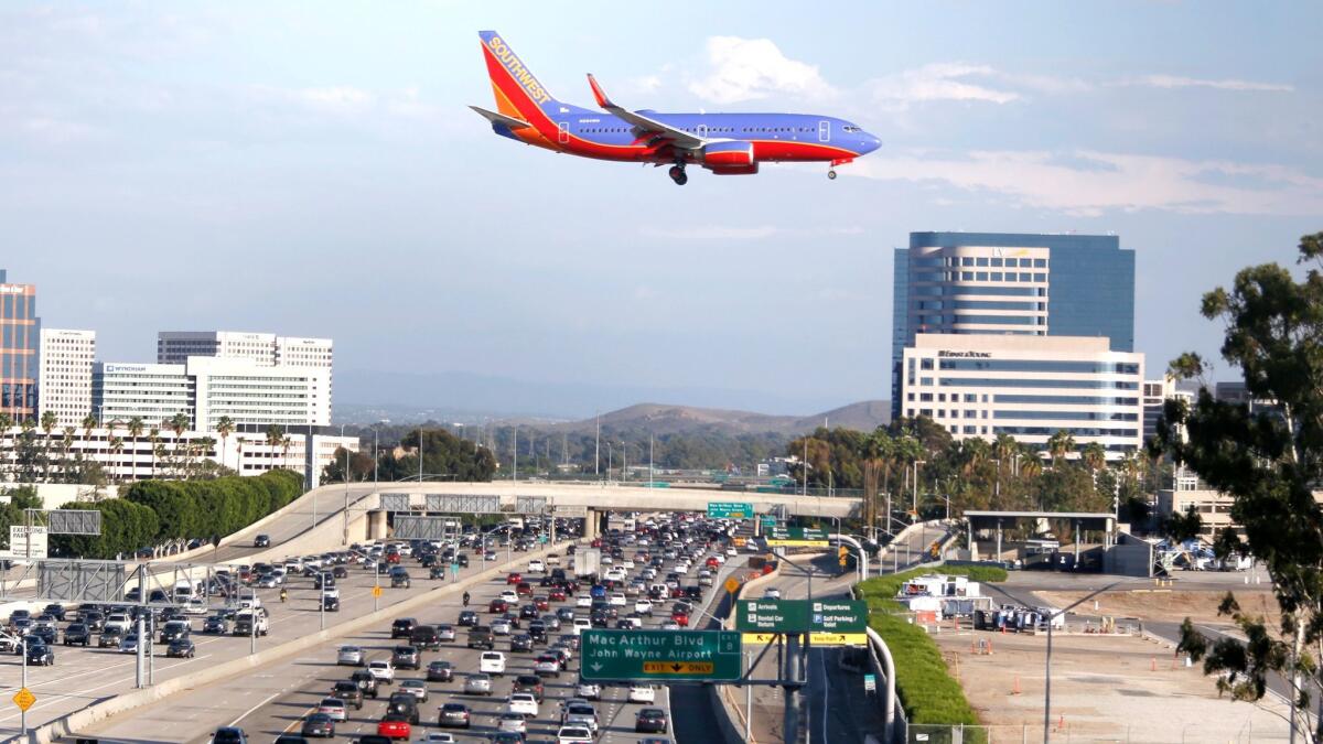 A plane flies over the 405 Freeway as it approaches the runway at John Wayne Airport in 2015.