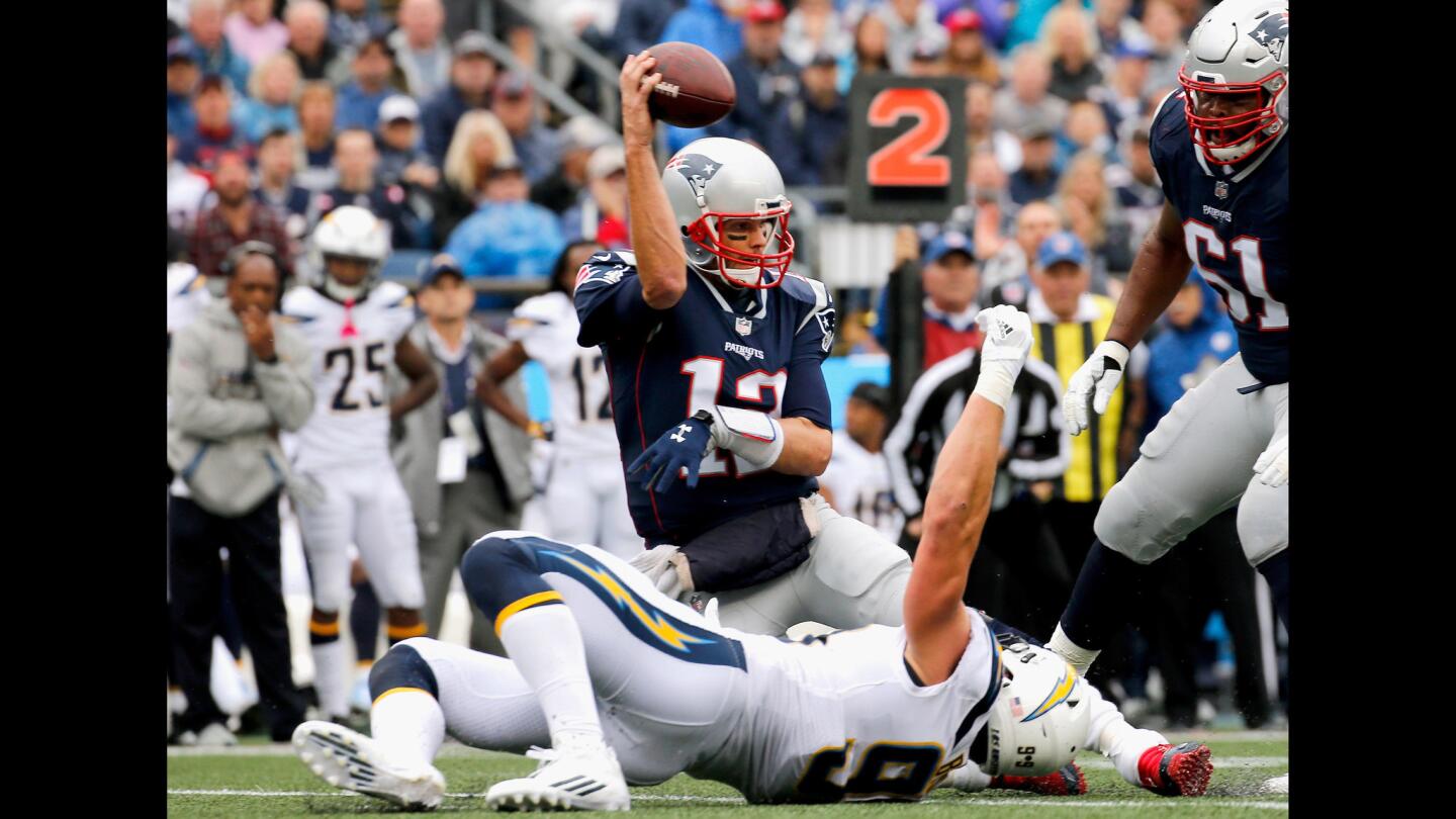 The Patriots' Tom Brady throws as he is tackled by the Chargers' Joey Bosa during the second quarter.