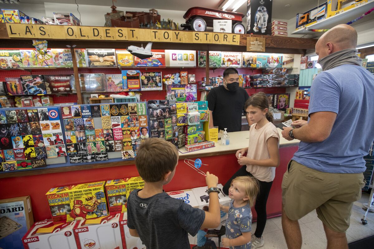 Children and their father shop for toys at Kip's Toyland in the Los Angeles Farmers Market.