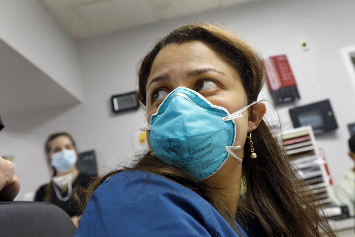 Medical student Engerlina Olivares, 29, center, looks at the scan of a patients lungs