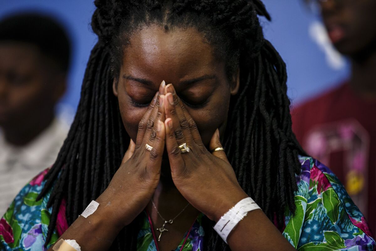 Shetamia Taylor listens during a news conference July 10, as her sons tell reporters of the night when a gunman killed five police officers and wounded seven others, including Taylor.