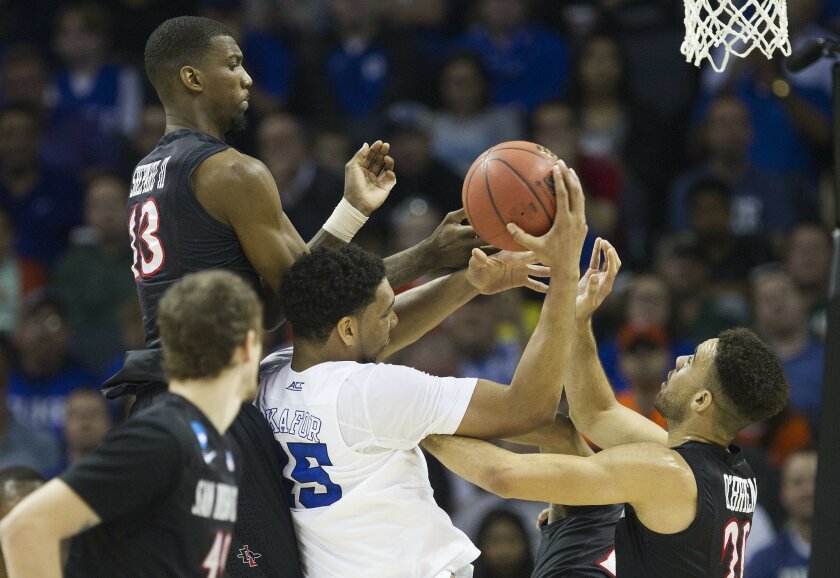SDSU lose to Duke in the third round of the NCAA Mens Basketball Tournament at Time Warner Cable Arena 68-49. San Diego State Aztecs forward Winston Shepard (13), and San Diego State Aztecs forward J.J. O'Brien (20) put pressure on Duke Blue Devils center Jahlil Okafor (15) in the first half.