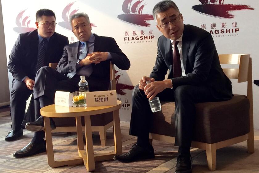 China Media Capital's Li Ruigang, right, and Warner Bros. chief executive Kevin Tsujihara, center, discuss the slate of their new joint venture, Flagship Entertainment, in Beijing.