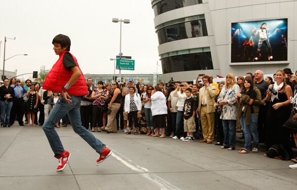Chris Escobar, 13, does the moonwalk for ticket holders before entering Staples Center for Michael Jackson's memorial.