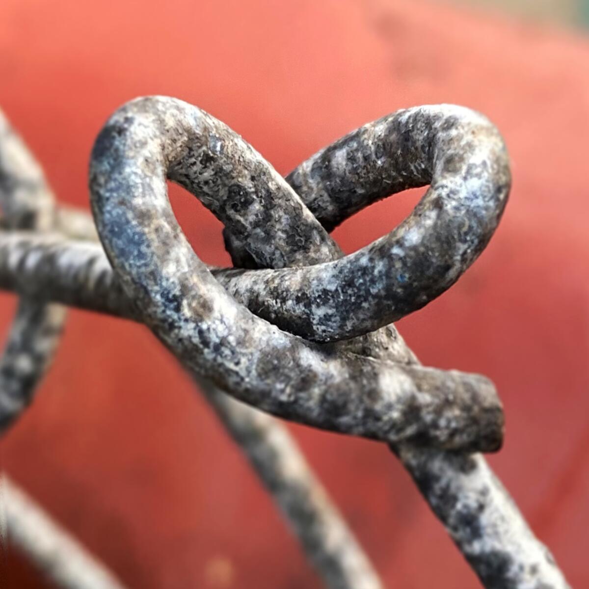 A heart-shaped portion of a chain-link fence.
