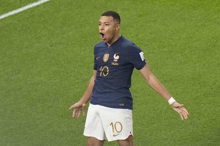 France's Kylian Mbappe, left, celebrates after scoring the third goal for his side during the World Cup round of 16 soccer match between France and Poland, at the Al Thumama Stadium in Doha, Qatar, Sunday, Dec. 4, 2022. (AP Photo/Luca Bruno)