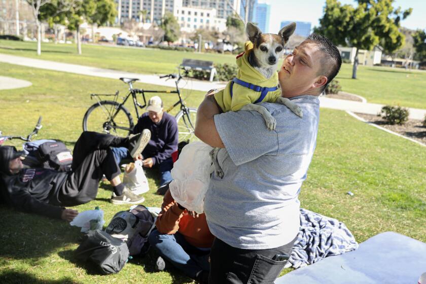SAN DIEGO, CA-FEB.27: Michele LeFlever plays with "Jack" next to a homeless encampment near the Embarcadero in San Diego on Monday, February 27, 2023 (Photo by Sandy Huffaker for The San Diego Union Tribune)